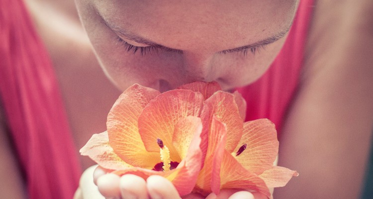 Woman smelling flower in her hands