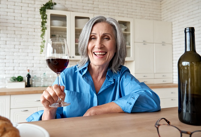 Happy mature woman drinking wine