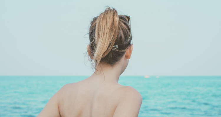 smooth back of woman facing ocean