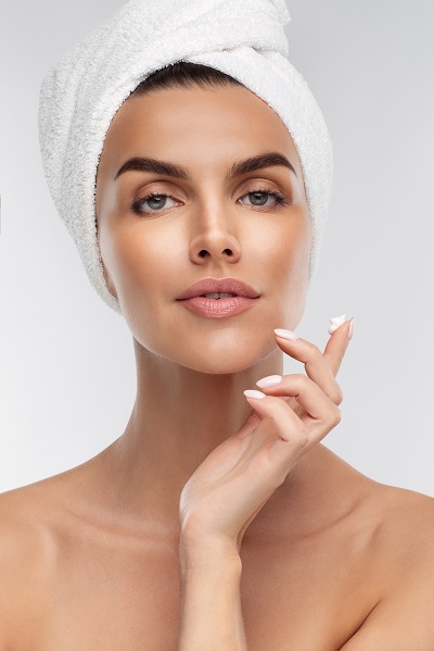 Woman applying serum on face for daily skincare routine