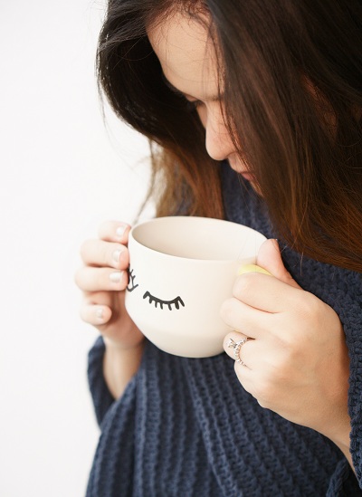 Woman drinking tea using a cute mug