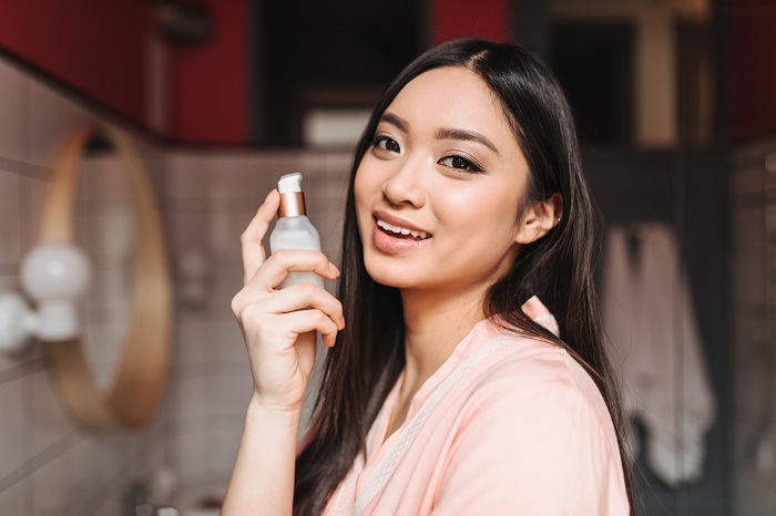 Woman holding a bottle of serum with organic ingredients