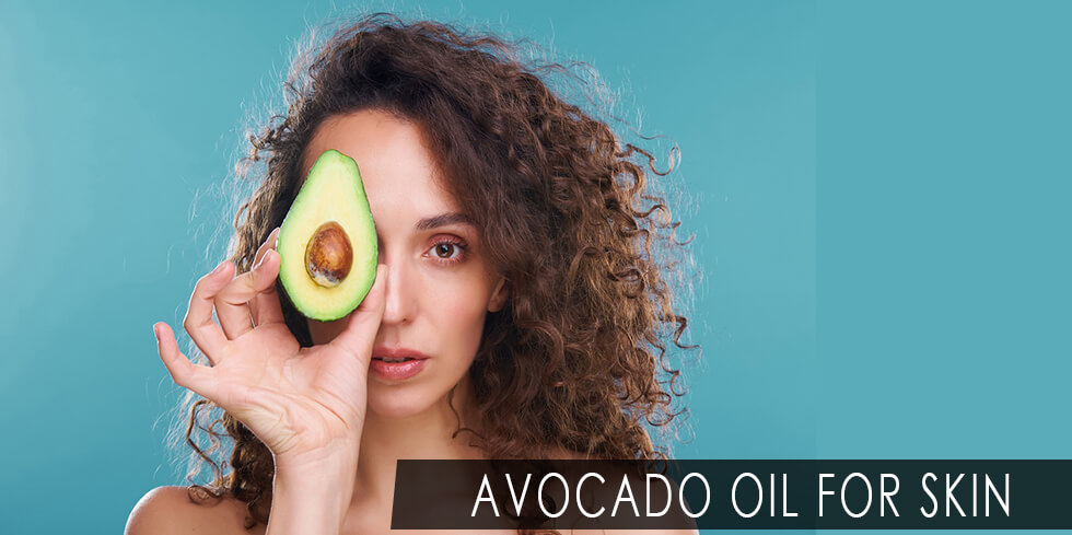 Woman holding a slice of avocado fruit