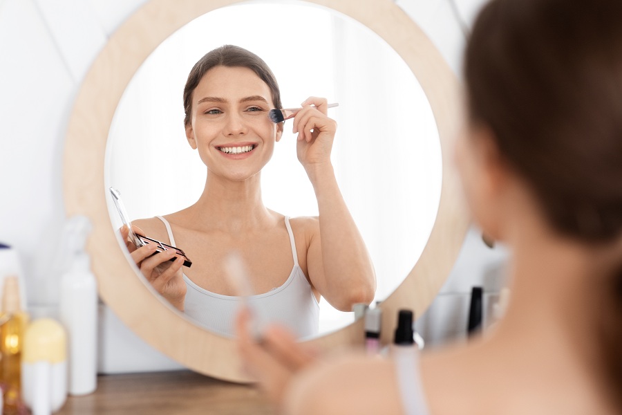 attractive lady doing light makeup before going out