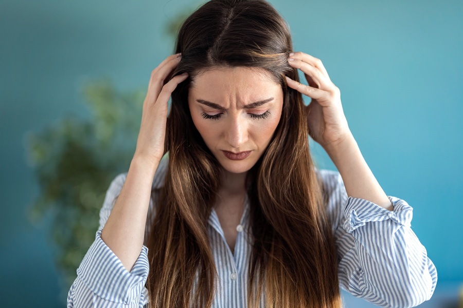 Frustrated young woman with headache and frowning
