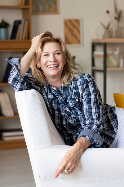 middle aged woman on a couch smiling