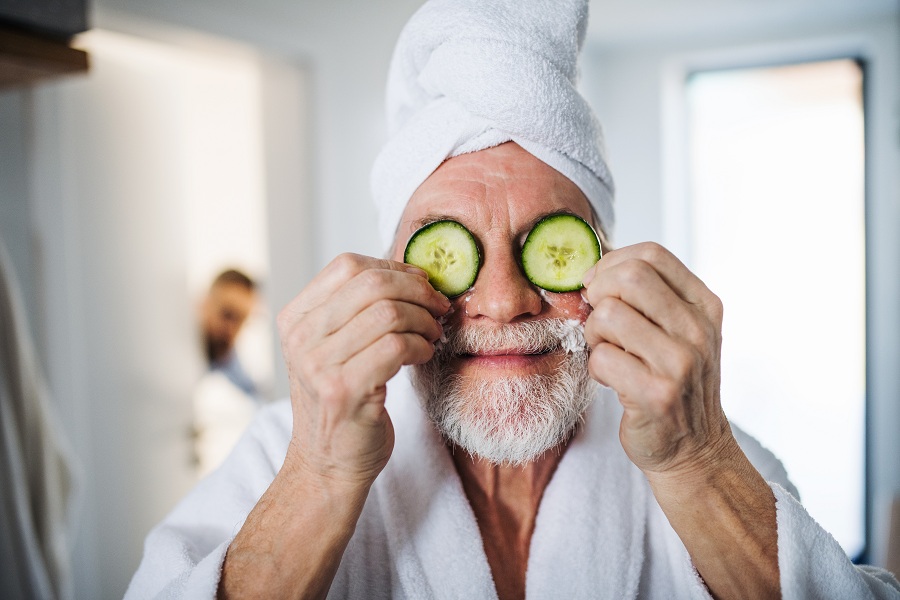 old man with cucumber home remedy for eyebags