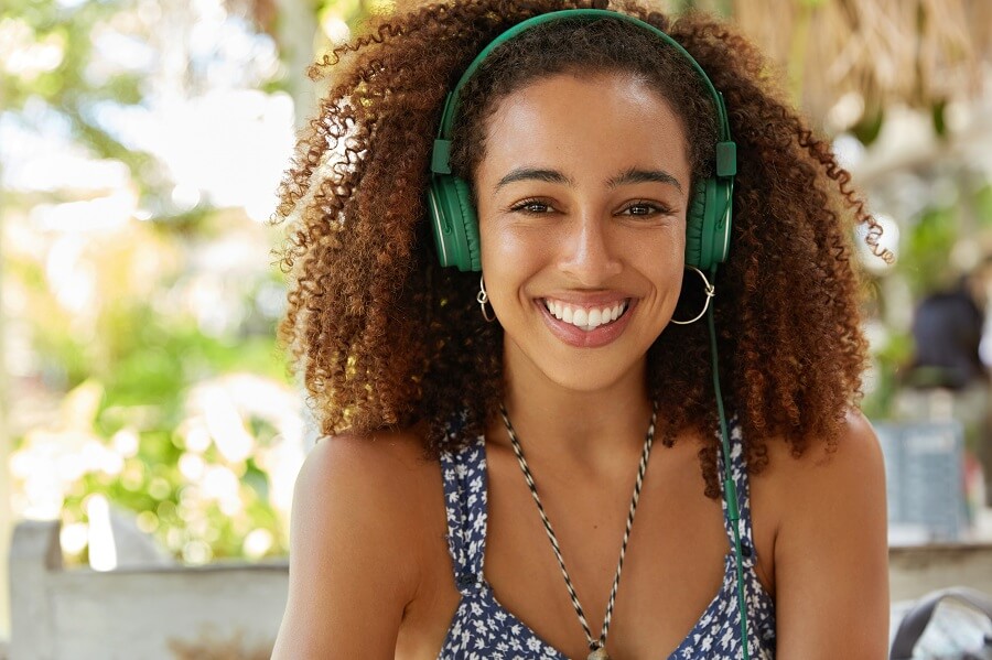 pretty young african american woman with green headphones