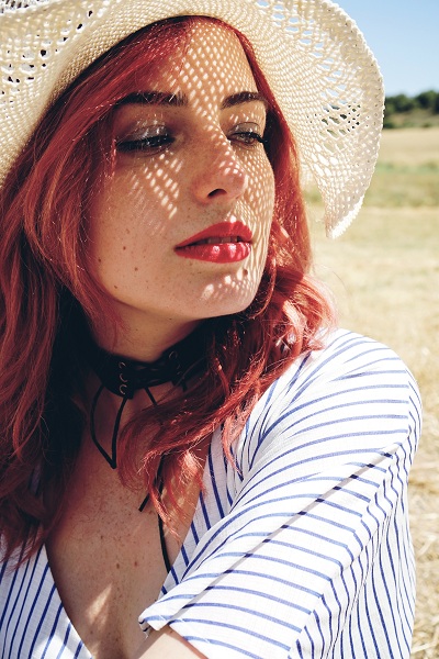 Young redhead woman covering from sun
