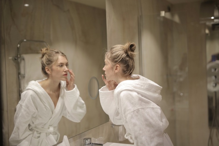 woman in bathtowel with mirror