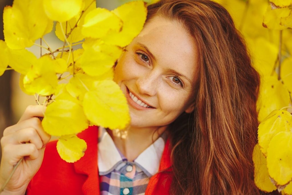 woman smiling on a photoshoot with yellow flowers