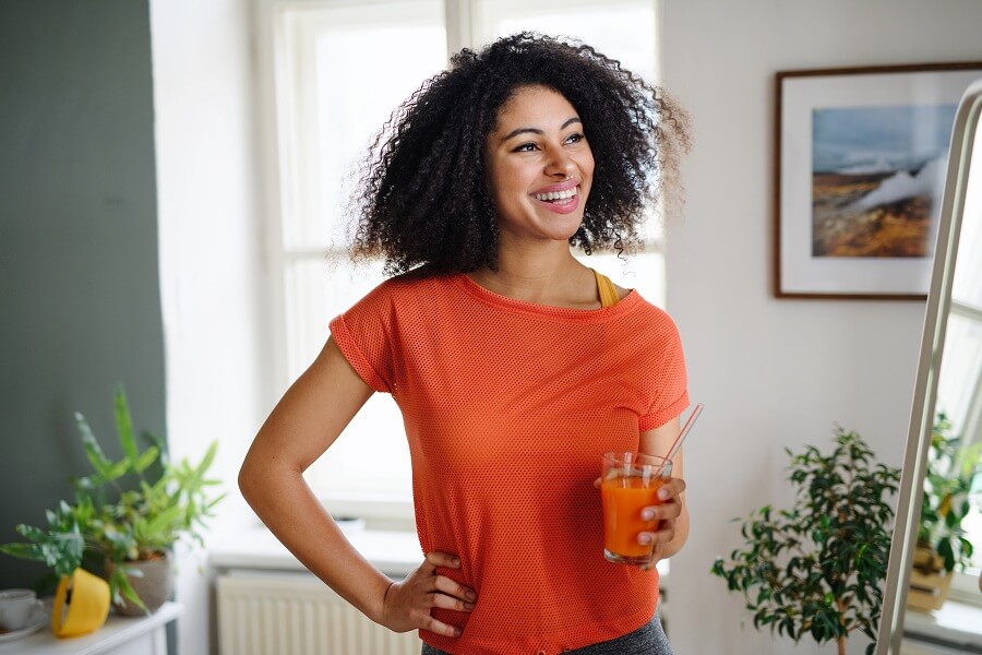 young woman with fair smooth skin holding a healthy drink